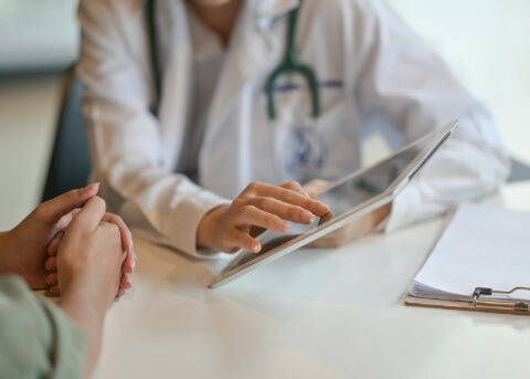 Doctor showing a tablet to a patient