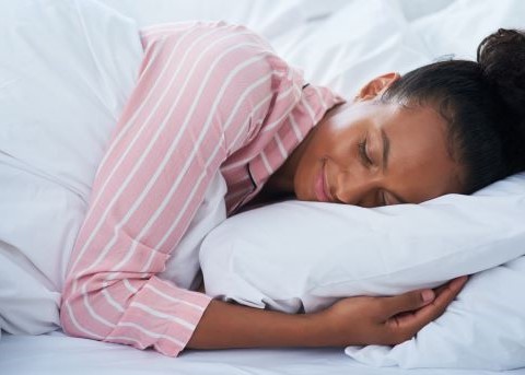 Woman smiling while sleeping on her side