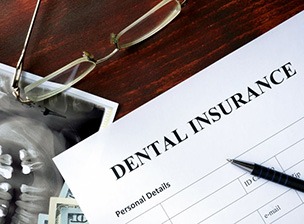 a dental insurance form next to a pair of glasses