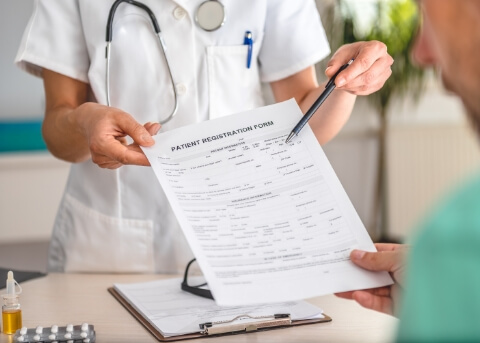 Medical professional handing paperwork to a patient