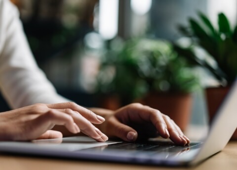 Close up of hands typing on laptop