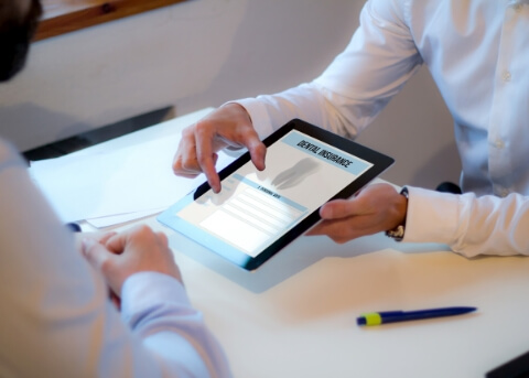 Two people looking at dental insurance information on a tablet