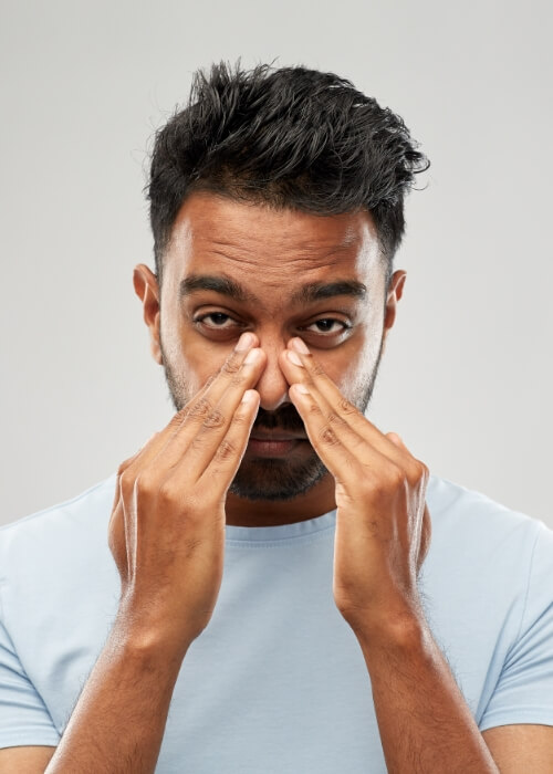 Tired man rubbing the bridge of his nose