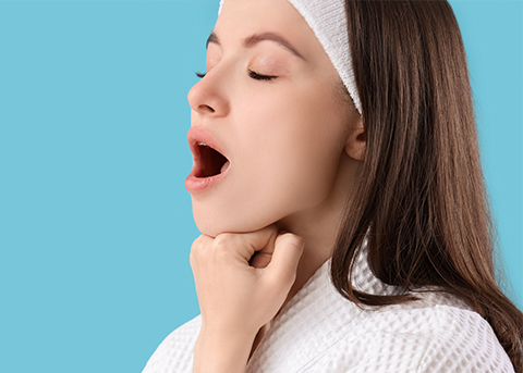 Woman opening her mouth with her fist pressed under her chin