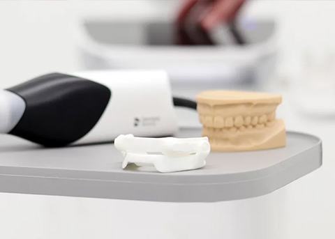 Tray with model of the teeth next to an oral appliance