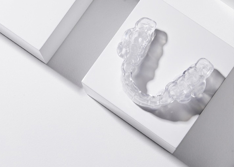 Clear oral appliance resting on white surface