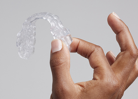 Hand holding a clear oral appliance