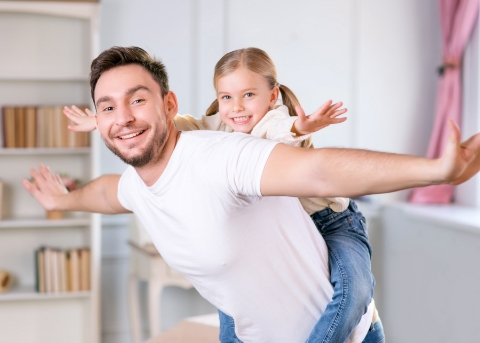 Man carrying his young daughter on his back