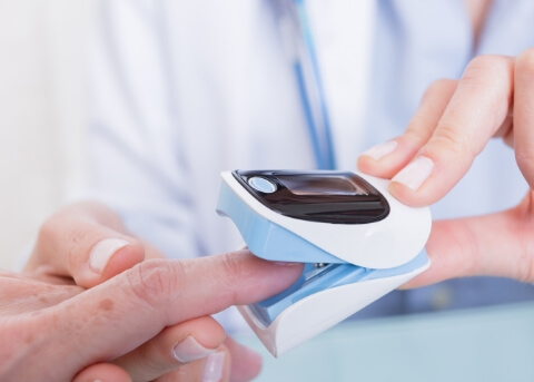 Doctor placing a pulse oximeter on a finger